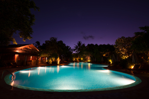 Luxury Villa Exterior With Swimming Pool And Lounge Chairs At Night