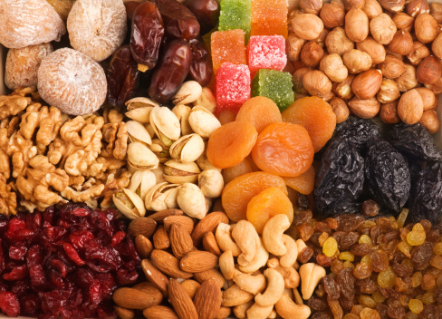 mixed nut and dried fruit in glass bowl on white table background.\