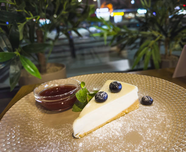vanilla cheesecake with blueberries, mint leaves, strawberry jam, powdered sugar