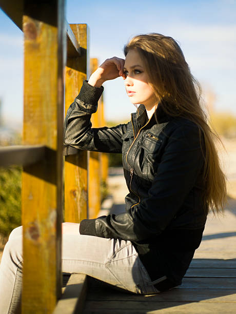 Woman sitting on the bridge, shadow falling on her eyes