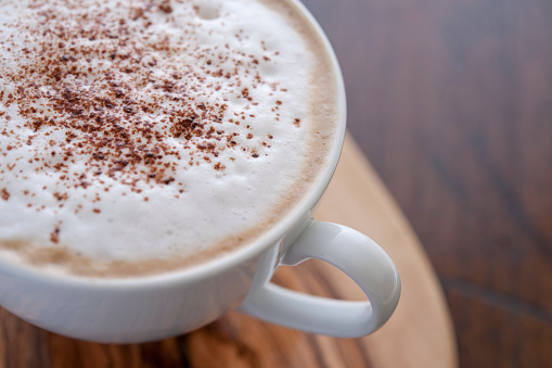 Cup of Cappuccino coffee topped with chocolate sprinkles.