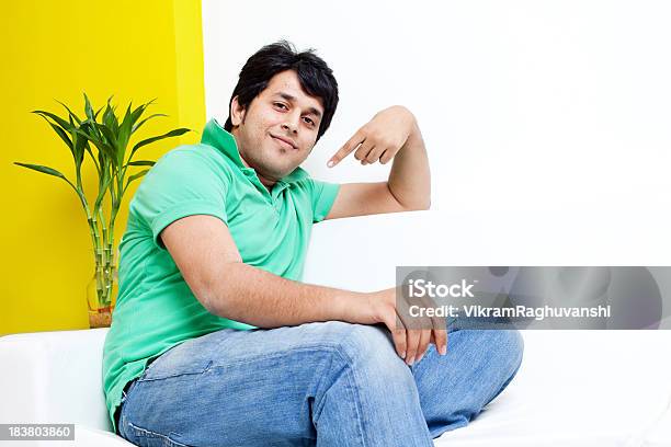 Młody Radosny Przystojny Indian Dorosły Mężczyzna Siedzi Na Kanapie - zdjęcia stockowe i więcej obrazów Pointing At Self