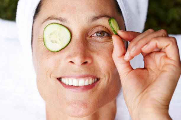 uśmiechnięta dojrzałych kobieta coraz zabieg kosmetyczny - cucumber human eye spa treatment health spa zdjęcia i obrazy z banku zdjęć