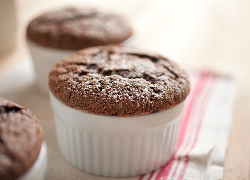 Freshly baked chocolate souffles dusted with powdered sugar