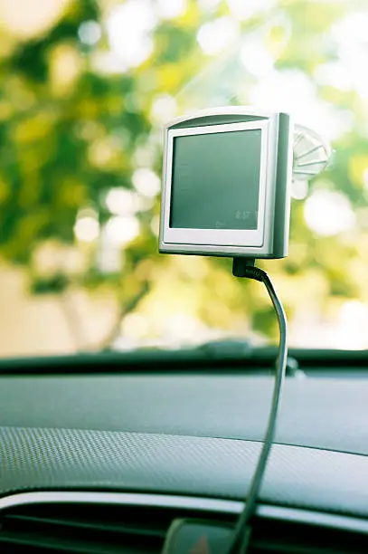 A GPS navigation system attached to the interior of a car's windscreen, or windshield if you prefer.