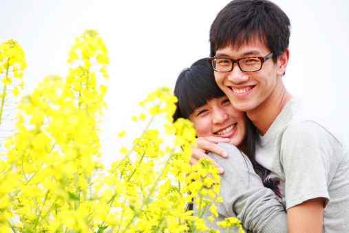 young asian couple together in the spring field