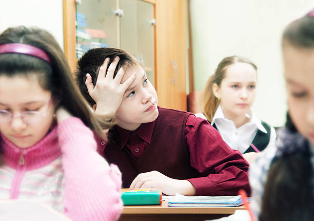 istock A schoolboy at his desk, looking away from the camera 183805495