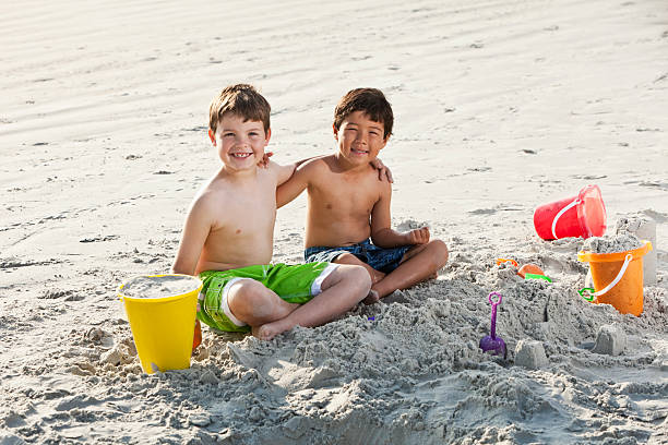istock Boys playing in sand at beach 183805569