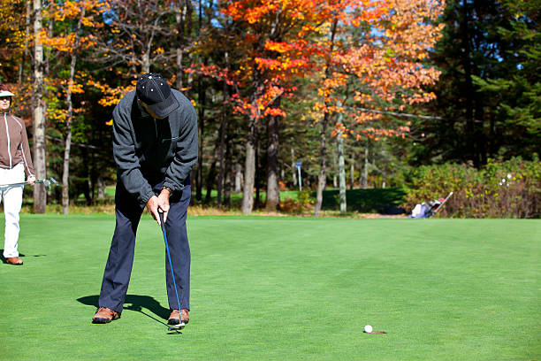 sênior casal em ação os jogadores de golfe no campo de golfe - senior couple golf retirement action - fotografias e filmes do acervo