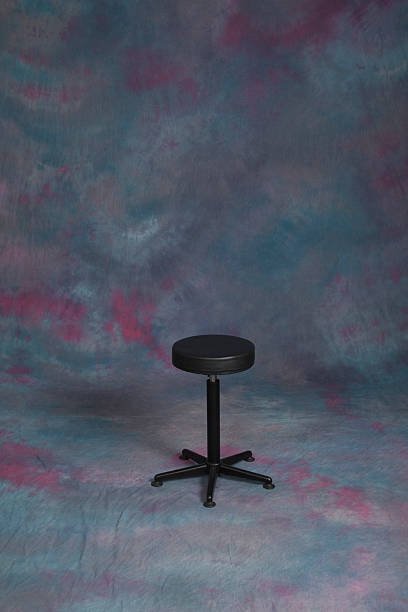 Photo Studio With Empty Stool On Blue Background Shown here is an empty stool sitting on a blue full frame backdrop in a photo studio. photo shoot stock pictures, royalty-free photos & images