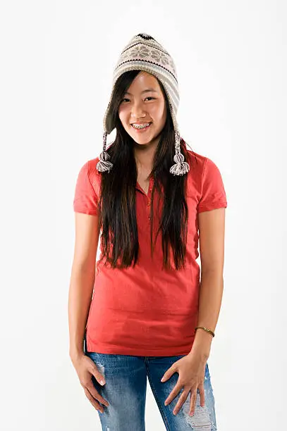 Happy Asian teen in casual clothing against white background.