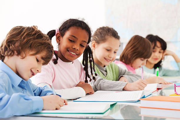 istock Children sitting in the classroom and writing. 183806447