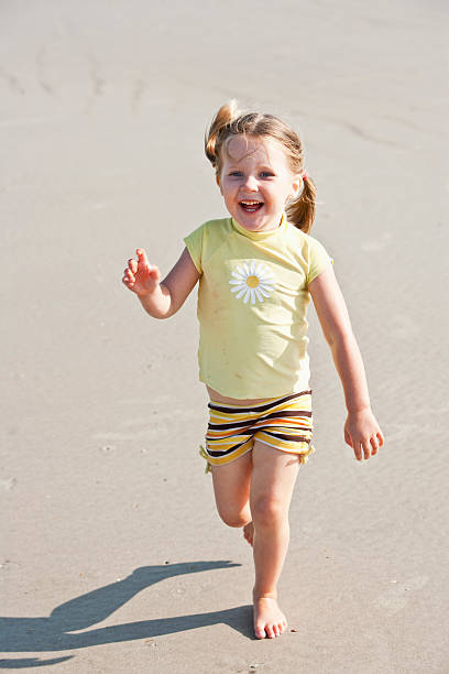 istock Cute little girl running on beach 183806836