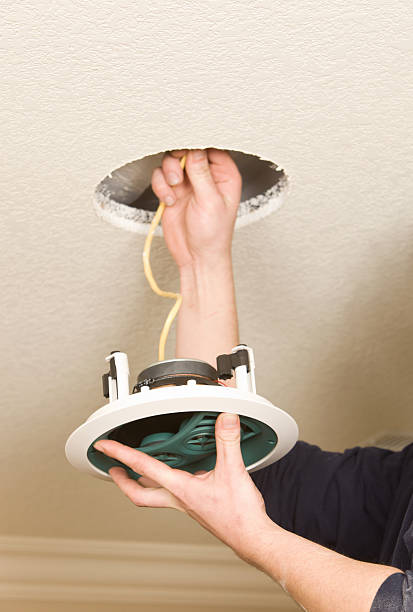 Worker Installing a Residential Ceiling Speaker  surround sound stock pictures, royalty-free photos & images