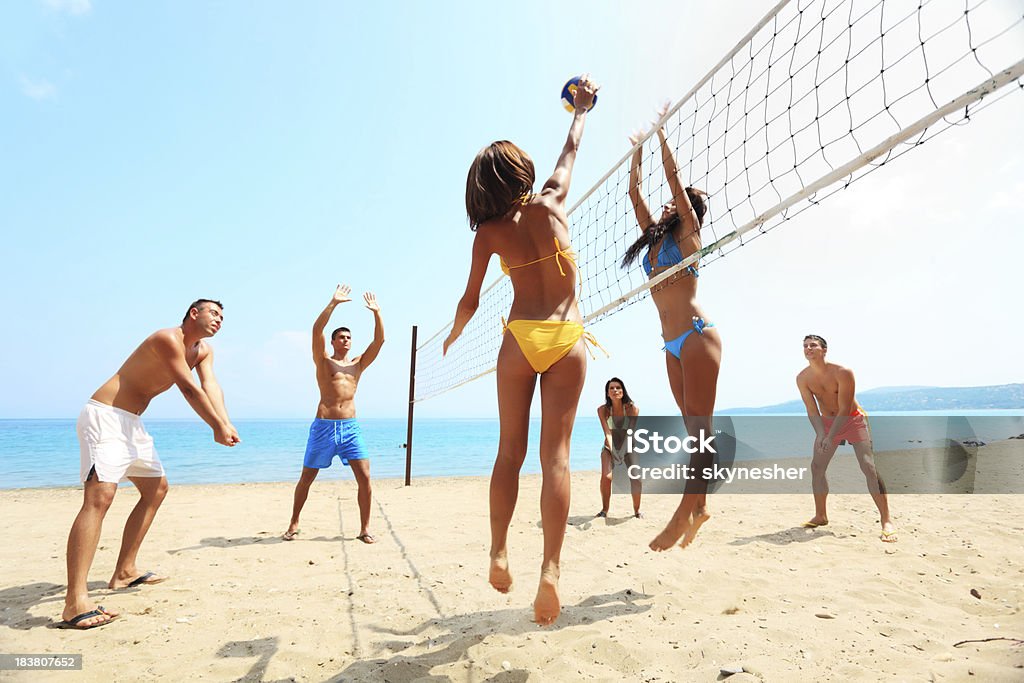 Groupe d'amis jouer au volley-ball sur la plage. - Photo de Beach-volley libre de droits