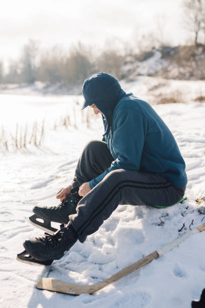 istock Senior male hockey player puts on skates before practice. 1838076872