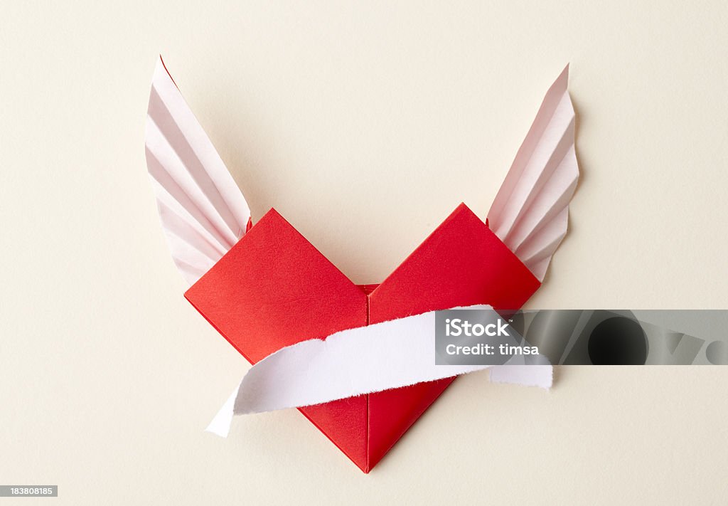 Origami a forma di cuore con ali e scorrere su Sfondo beige - Foto stock royalty-free di Ala di animale