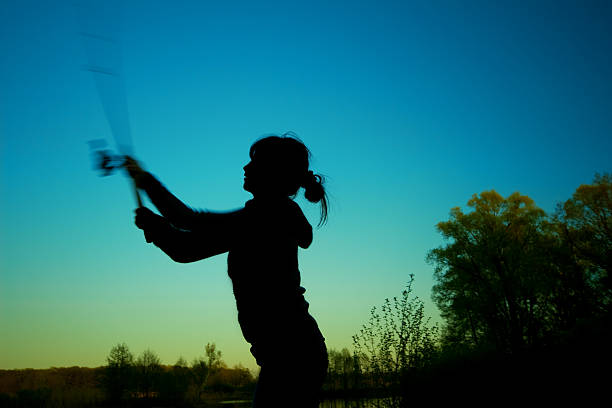 girl with  fishing rod  by the river against  sunset stock photo