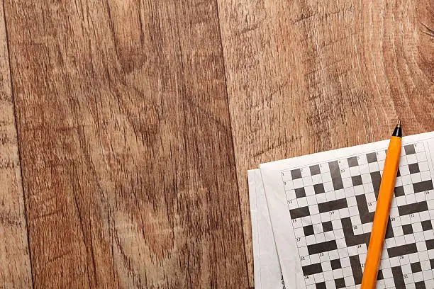 Crossword and pen on a wooden background