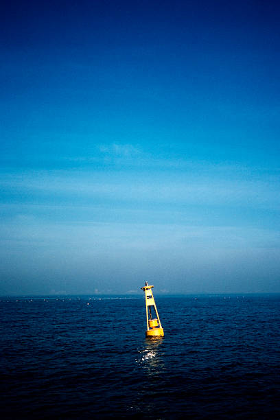 Yellow buoy on the water against blue sky in Tokyo bay.