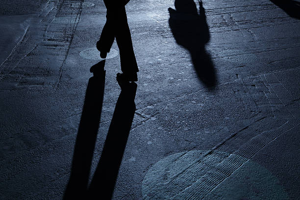 istock Lone man walking past ominous blue night shadows 183809887