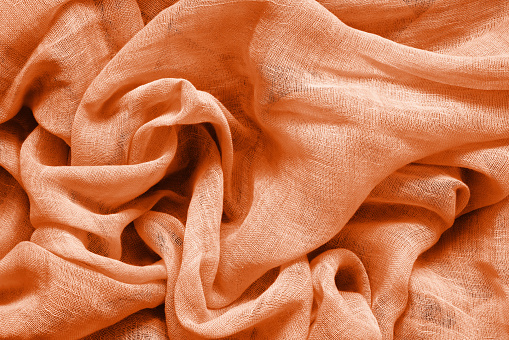 Peach fuzz color cotton fabric background. color trend 2024. Copy space, top view