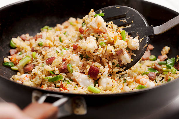 Pan cooking fried rice for dinner Fried Rice with shrimp and roast pork in a wok. fried rice stock pictures, royalty-free photos & images