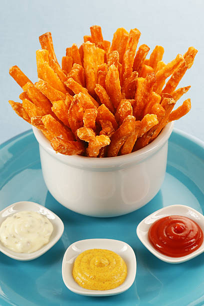 Sweet potato fries with mayonnaise, mustard and ketchup dips Kid's style freshly made sweet potato fries with catsup, mustard, and herbed aioli. sweet potato french fries stock pictures, royalty-free photos & images