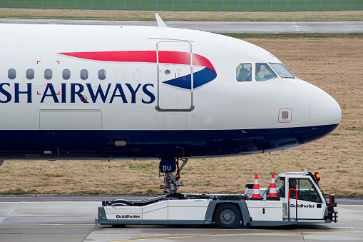 British Airways Airbus A321 is being tugged to a hangar for maintenance