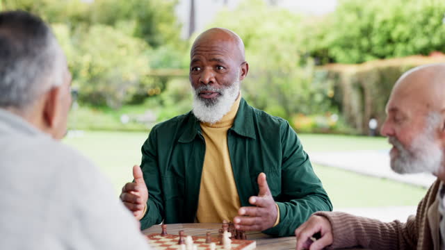 Man, chess and game with talk for strategy by planning to win in park, garden or outside. Elderly people, friends and together for fun, challenge or tournament for play in retirement with competition