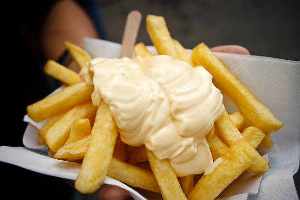 Homem segurando batata chips com maionese - foto de acervo