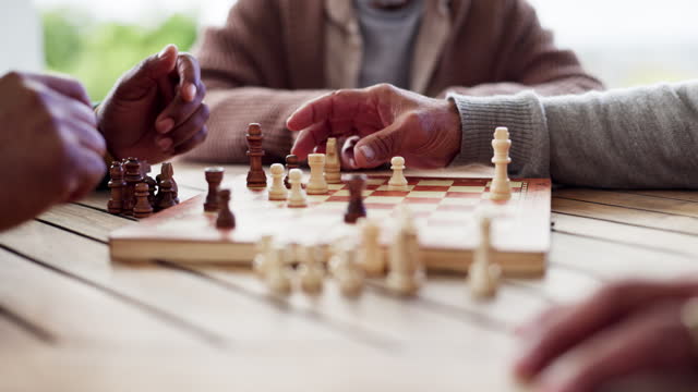 Hands, chess and game for strategy in closeup of board, challenge or tournament for outside, park or garden. Elderly people, together and fun with activity for thinking, problem solving and planning
