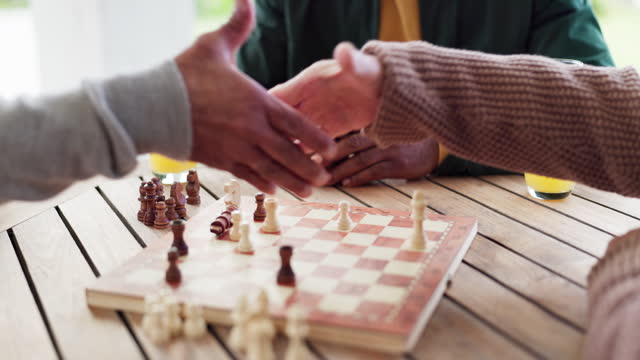 People, chess and handshake for checkmate for win on board in closeup with congratulations for game. Person, planning and strategy in competition, challenge or tournament by table, park or outside