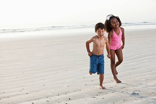 istock Children playing together on beach 183812116