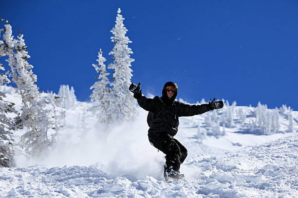 Looking down a slope at Snowbasin ski resort in northern Utah, with a snow-covered mountain range in the distance.