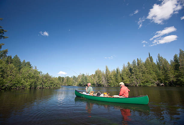 Two Men Canoeing and Fly Fishing on The Brule River.