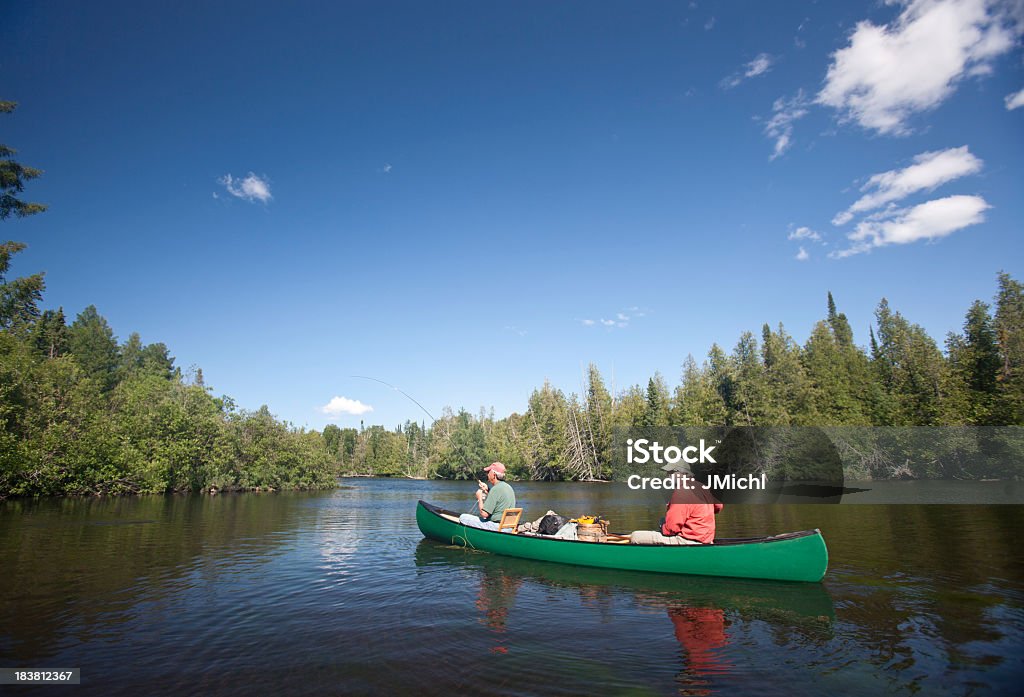 Dois homens canoagem e pesca com mosca no brulé rio. - Foto de stock de Terceira idade royalty-free