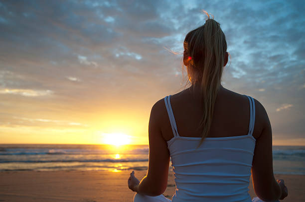 istock Woman doing yoga on the beach 183813253