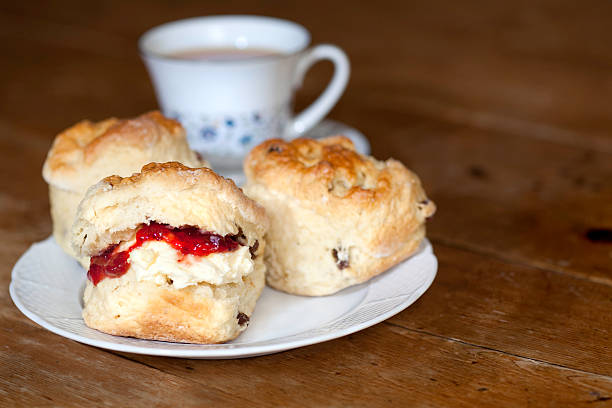 istock Delicious scones, cream and jam on a wooden table 183814030