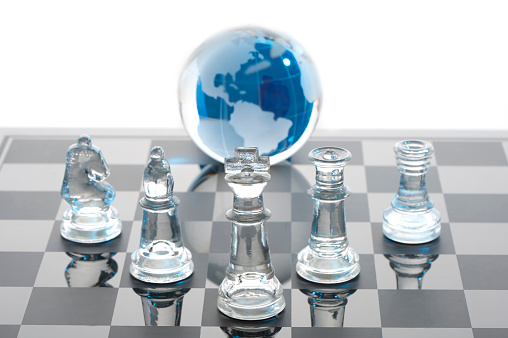 Global Strategy concept using glass globe and chess pieces showing The Americas