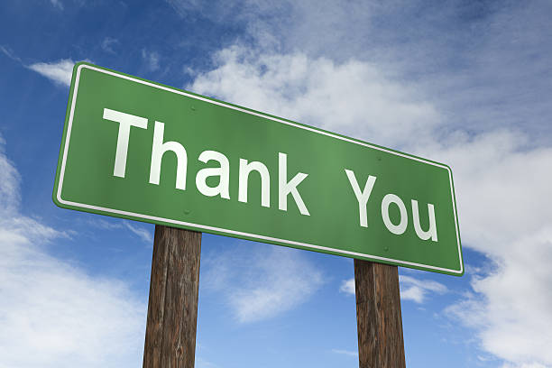 Green thank you sign over a blue sky background