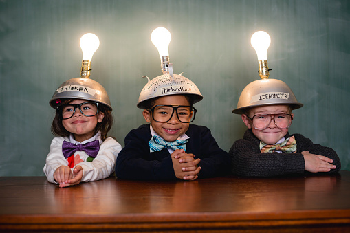 A group of young nerd children are thinking of the next big idea.