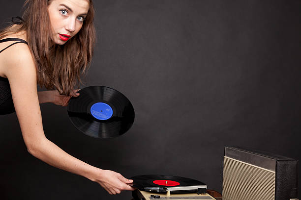 istock Young woman putting on a vintage record 183816669