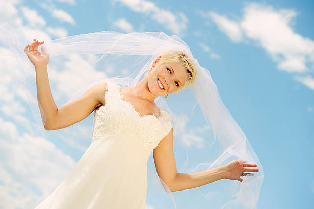 istock Beautiful Bride Standing Against A Cloudy Blue Sky 183816912