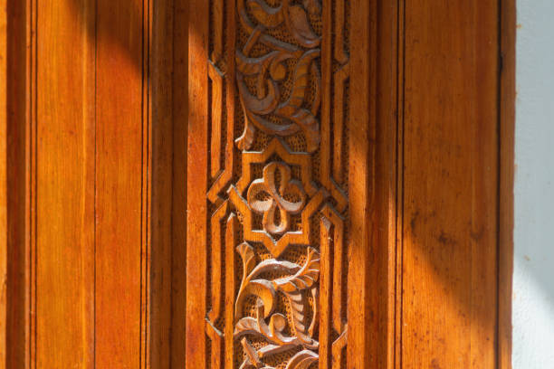 big old wooden door decorated with various symbolic signs carved directly on the canvas of massif. example of exterior and interior decoration of entrance lobbies in different cultures around world - antique furniture old old fashioned imagens e fotografias de stock