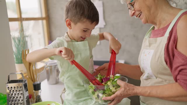 Boy and great grandmother preparing a salad