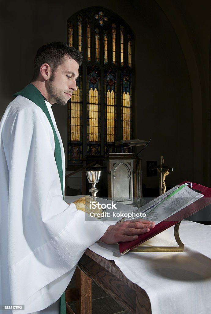 Священник чтение Молитвенный книгу в темные Церковь - Стоковые фото Священник роялти-фри