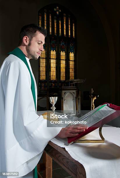 Священник Чтение Молитвенный Книгу В Темные Церковь — стоковые фотографии и другие картинки Священник