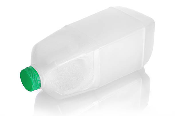 Unlabeled milk jug laying on side with reflection on white Blank plastic white milk jug isolated on white with green cap. Object laid down on its side. milk bottle milk bottle empty stock pictures, royalty-free photos & images