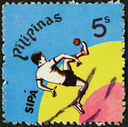 boy kicking a ball on an old Philippine postage stamp